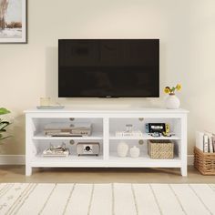 a flat screen tv sitting on top of a white entertainment center in a living room