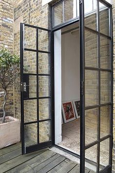 an open door leading into a room with brick walls and wooden flooring on the outside