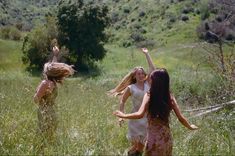 three girls are playing in the tall grass