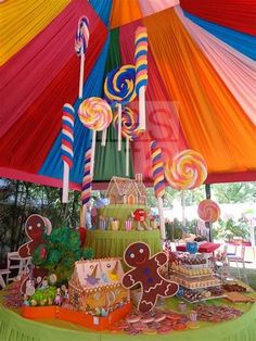 a table topped with lots of colorful candy and lollipops covered in icing