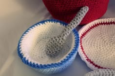 three crocheted bowls and a spoon on a white surface