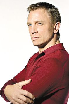 a man in a red shirt is posing for the camera with his arms folded out