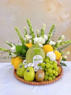 a basket filled with fruit and flowers on top of a table