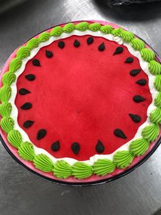 a watermelon cake with green icing and black dots on it's edges