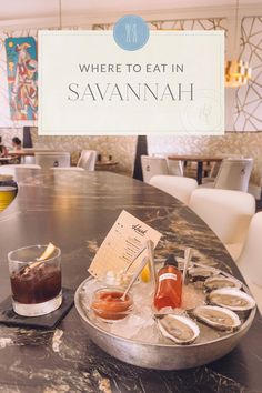 there is a sign that says where to eat in savannahh and oysters on the table