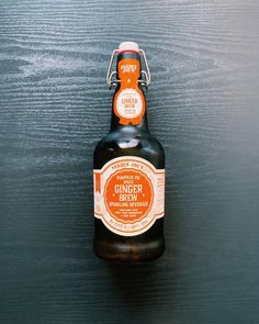 a bottle of ginger ale sitting on top of a wooden table