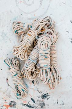 several pieces of rope on the ground with paint splattered all over them and one piece missing