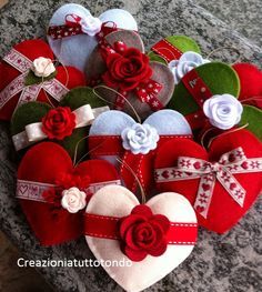 several heart shaped ornaments are arranged on a granite surface with ribbons and flowers in the center