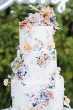 a white wedding cake with flowers on it