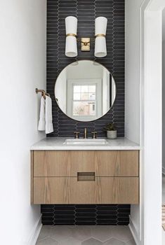 a bathroom with a sink, mirror and two lights on the side of the wall