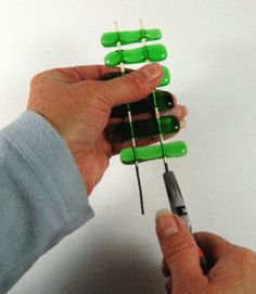 two hands are holding green toothpicks in each other's fingers and pointing at them