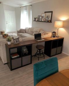 a living room filled with furniture and a laptop computer on top of a wooden table