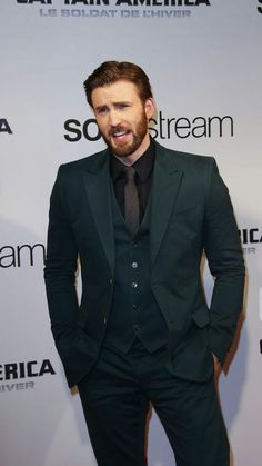 a man in a suit and tie making a funny face on the red carpet at an american cinema awards event