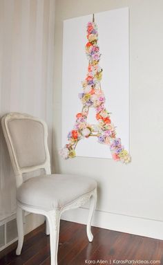 the eiffel tower is made out of flowers and has a white chair next to it