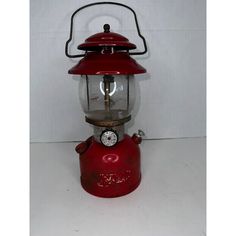 an old fashioned red fire hydrant with a light on top