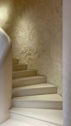 there is a white stair case in the room with wall paper on the walls and floor