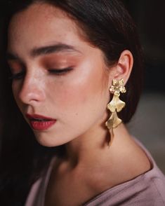 a close up of a person wearing some kind of earring with flowers on it