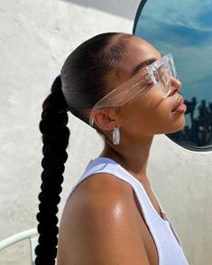 a woman wearing safety goggles looking into a mirror