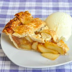 a piece of pie and ice cream on a white plate with blue checkered tablecloth