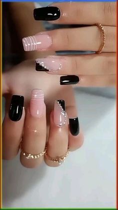 a woman's hands with black and pink nail polishes on their nails, one is