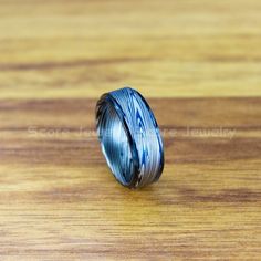 a ring with blue and white stripes on it sitting on top of a wooden table