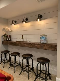 a bar with four stools in front of it