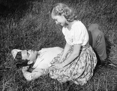 an old black and white photo of two women laying on the ground with each other