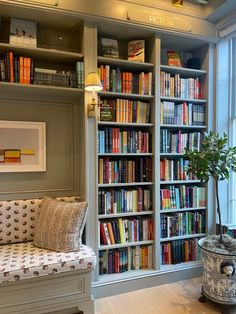 a room filled with lots of books on top of a book shelf next to a window