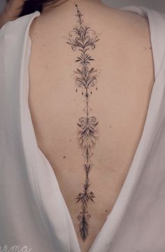 the back of a woman's neck is covered with flowers and leaves on it