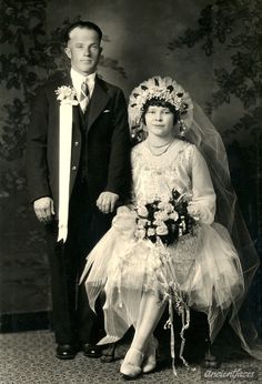 an old black and white photo of a man and woman dressed up for their wedding