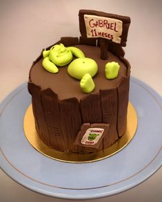 there is a cake that has been made to look like a tree stump with some animals on it