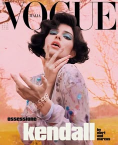 a magazine cover with a woman holding her hand up to her face and looking at the camera