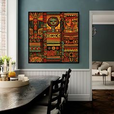 a dining room table with chairs and a painting on the wall above it that is decorated in african style