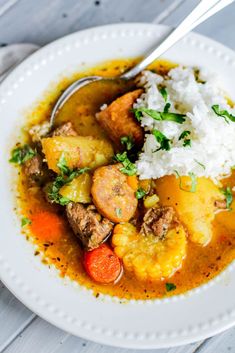 a white plate topped with stew and rice