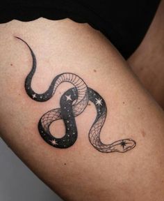 a woman's thigh with a snake tattoo on the side and stars in the middle