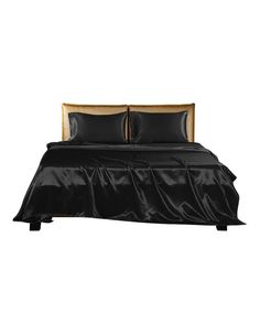 a bed with black sheets and pillows on it