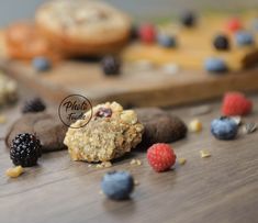 an assortment of cookies and berries on a wooden table