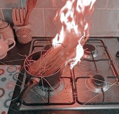 a person stirring something in a pot on top of a stove with flames coming out of it