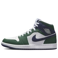 The Air Jordan 1 Mid SE 'Noble Green' is a stylish and modern sneaker that is perfect for any occasion. Featuring a leather upper with white panels and a green and navy blue overlay, this sneaker is sure to turn heads. The rubber sole and white laces provide a comfortable and secure fit. This sneaker is part of the Air Jordan 1 Mid series, inspired by the classic Air Jordan 1 silhouette. The Noble Green colorway is a luxurious combination of green, midnight navy and white, making it the perfect Air Jordan 1 Shoes, Jordan 1 Shoes, Wmns Air Jordan 1, Blue High Tops, Air Jordan 1 Mid Se, Marina Blue, Nike Air Jordan 1, University Blue, Air Jordan 1 Mid