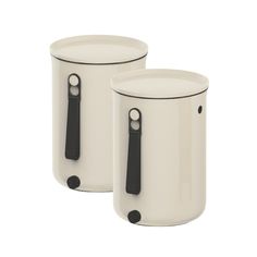 two white ceramic containers with black handles