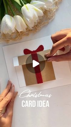 two hands holding a card with a bow on it and the words christmas card idea