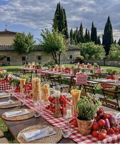 an outdoor dining area with tables covered in red and white checkered tablecloths