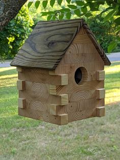 a wooden birdhouse hanging from a tree