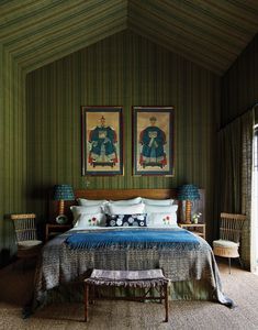 a bedroom with two paintings on the wall and a large bed in front of it