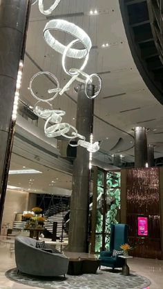 the lobby is clean and ready to be used for business or hotel guests, with modern chandeliers hanging from the ceiling