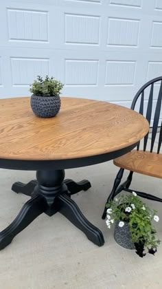 a wooden table and two chairs sitting on the cement ground next to a garage door