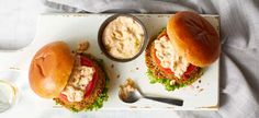 two burgers on a tray with dip