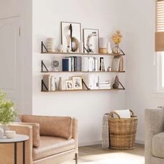 a living room with two couches and some bookshelves on the wall above them