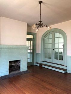 an empty living room with a fireplace and french doors