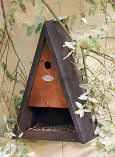 a bird house hanging on the side of a wall